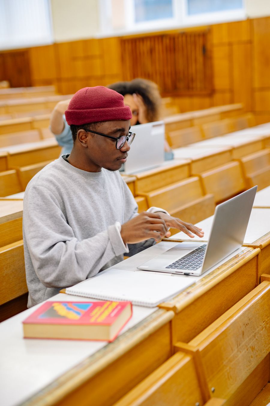 Student working on a laptop in a lecture hall
